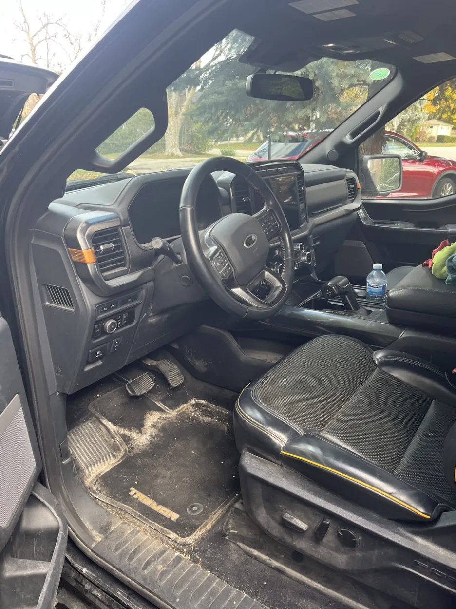 Before: Dirty Ford F-150 Tremor interior with dirt on floor mats